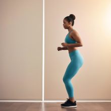 Woman performing a bodyweight movement indoors, emphasizing balance and coordination exercises that support brain function.
